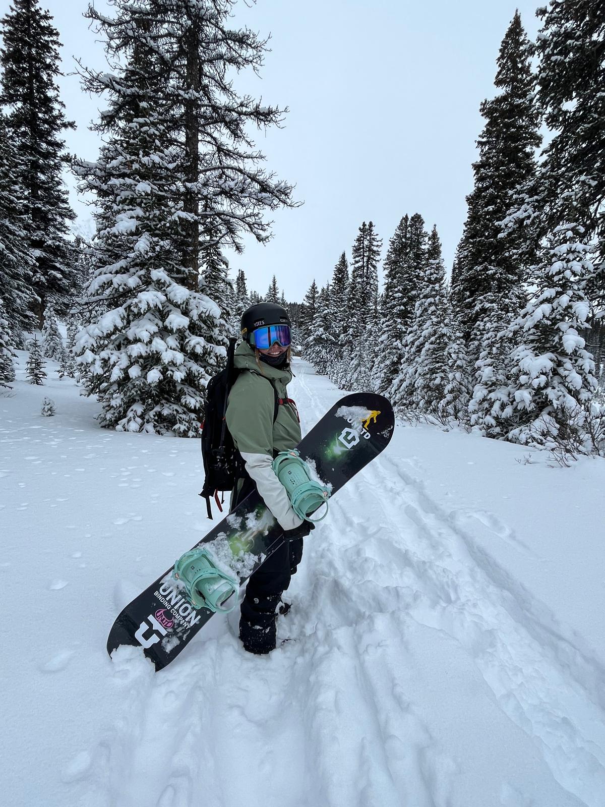 Emily Golds smiling with her snowboard 