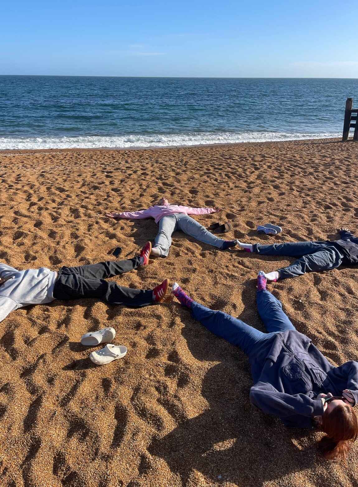 Girls making a star with our legs at the beach